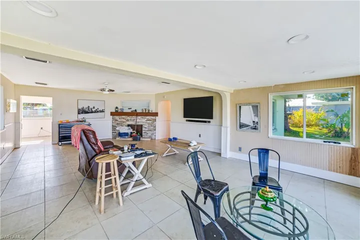 Tiled dining area featuring ceiling fan and a fireplace
