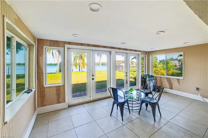 Sunroom featuring a water view, plenty of natural light, and french doors