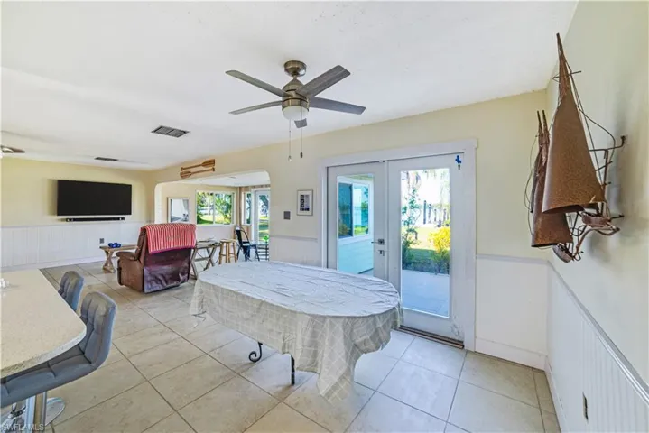 Tiled dining area with ceiling fan and french doors