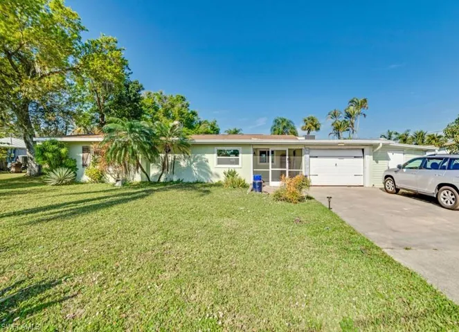 Single story home featuring a garage and a front lawn