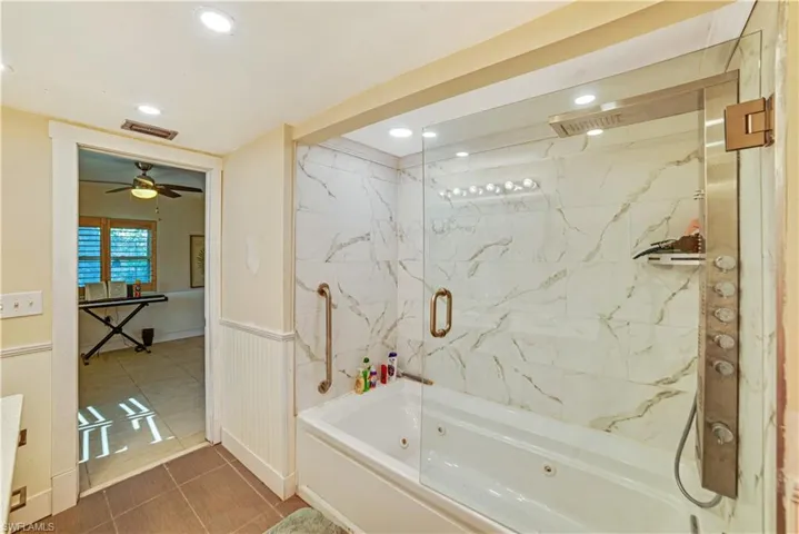 Bathroom featuring tiled shower / bath combo, tile patterned floors, and ceiling fan