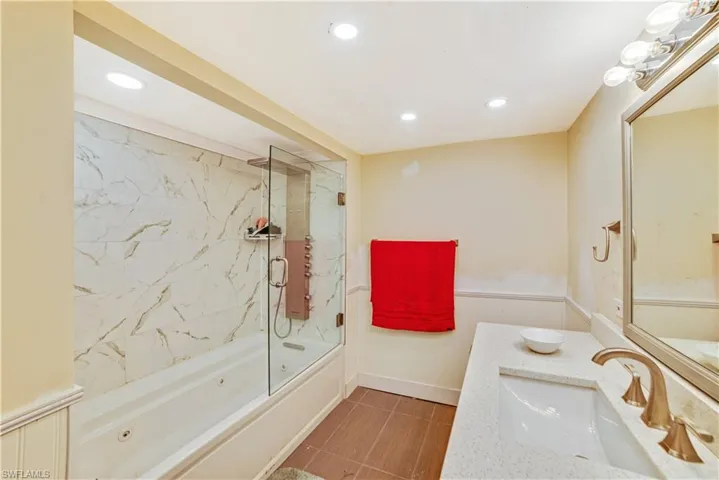 Bathroom featuring bath / shower combo with glass door and vanity
