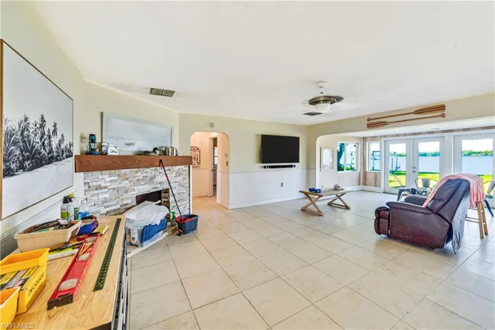 Tiled living room featuring a fireplace and french doors