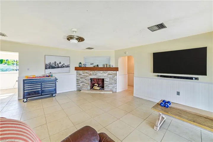 Tiled living room with a textured ceiling and a fireplace