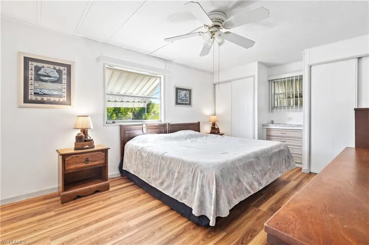 Bedroom with two closets, light wood-type flooring, and a ceiling fan
