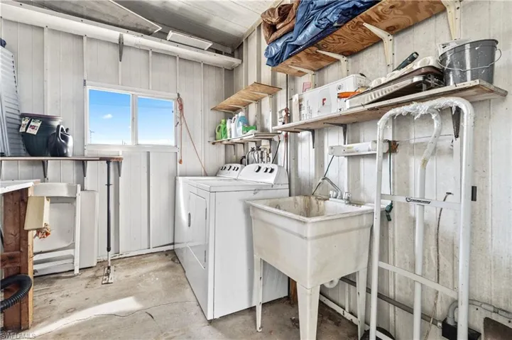 Laundry area with unfinished concrete flooring and washing machine and dryer