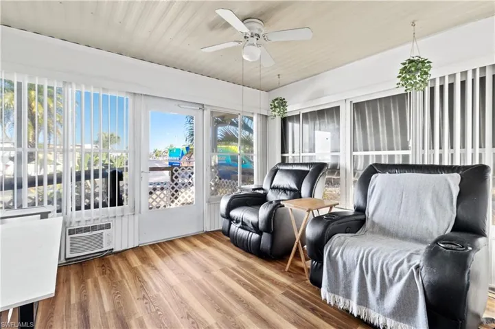 Sunroom / solarium featuring ceiling fan, wood finished floors, and wooden ceiling
