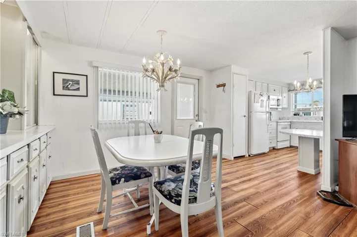 Dining area featuring suspended lighting, light wood-style floors, and a textured ceiling