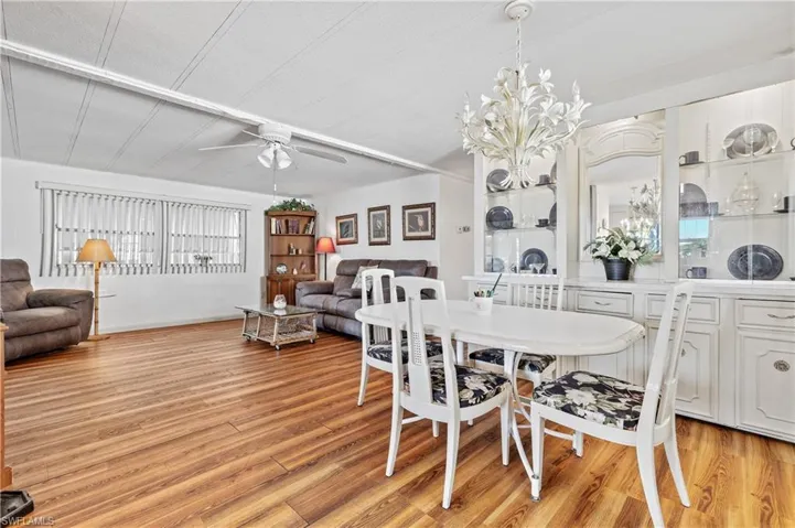 Dining space with light wood-style floors, a ceiling fan, and a chandelier