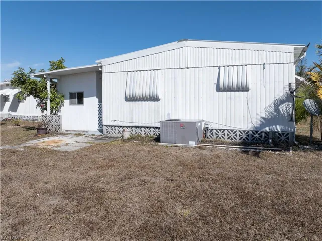 View of side of home with a yard and a patio