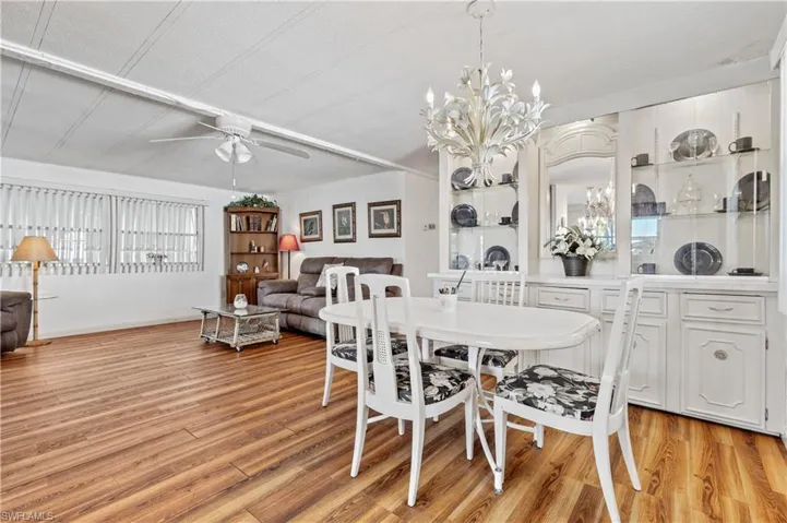 Dining room with a ceiling fan, hanging lights, and light wood-style floors