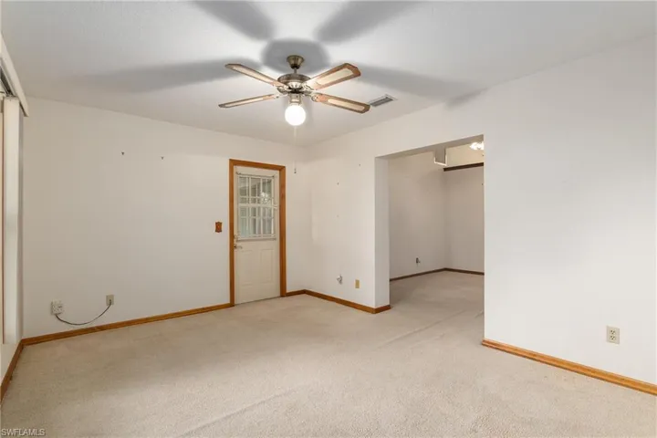 Unfurnished room with light colored carpet and ceiling fan