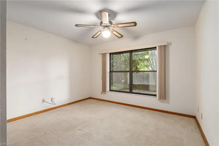 Carpeted empty room with ceiling fan