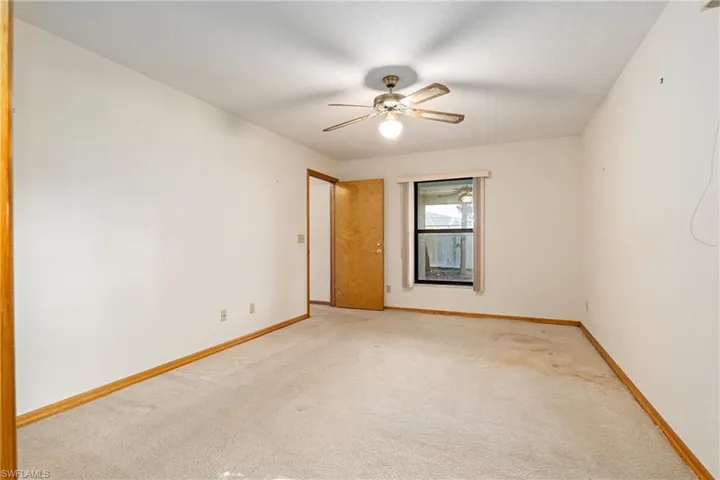 Spare room featuring light colored carpet and ceiling fan