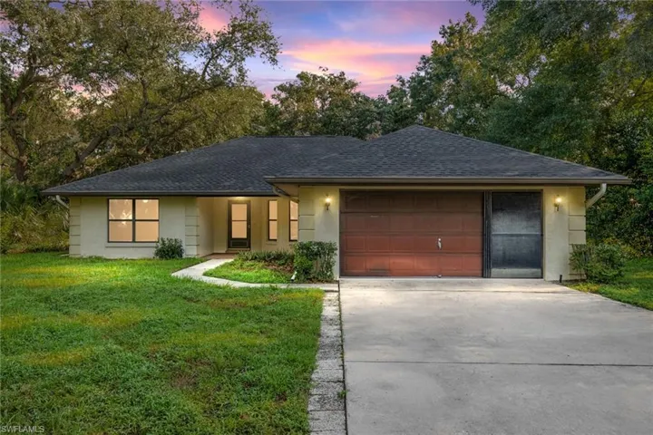 Ranch-style house with a garage and a yard