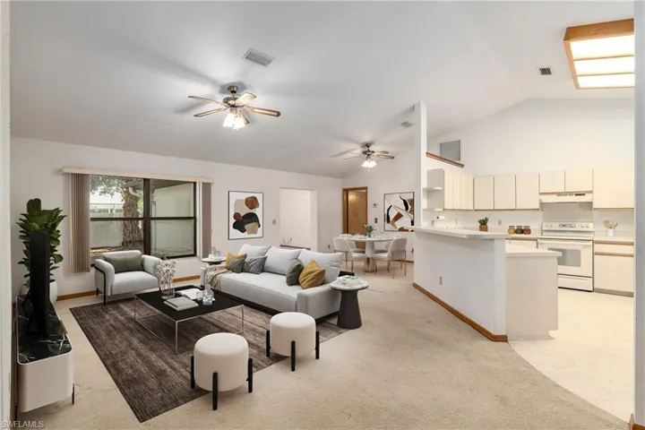 Living room featuring high vaulted ceiling, light carpet, and ceiling fan