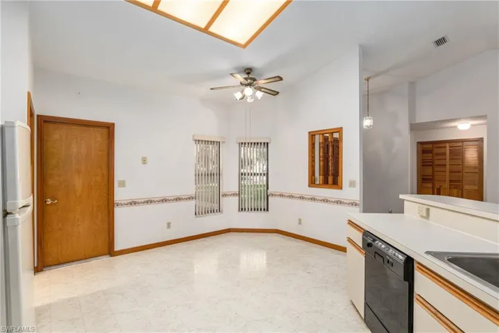 Kitchen with light tile patterned floors, dishwasher, ceiling fan, stainless steel fridge, and sink