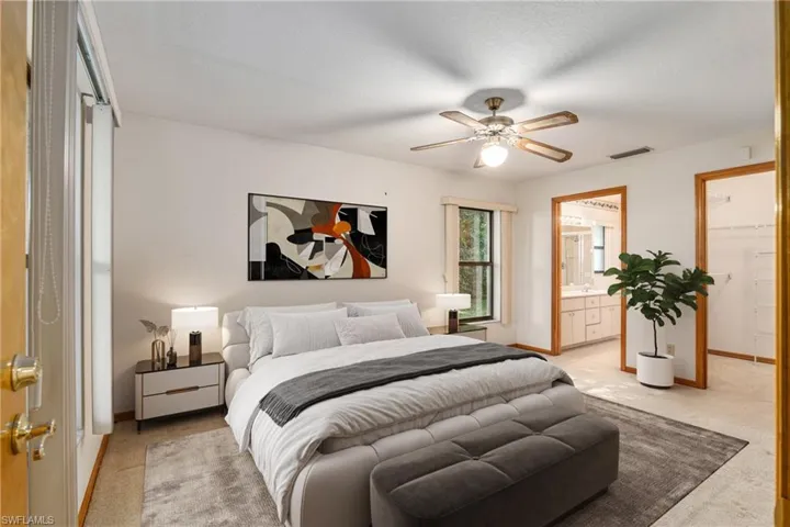 zBedroom with a closet, ensuite bathroom, ceiling fan, and a spacious closet