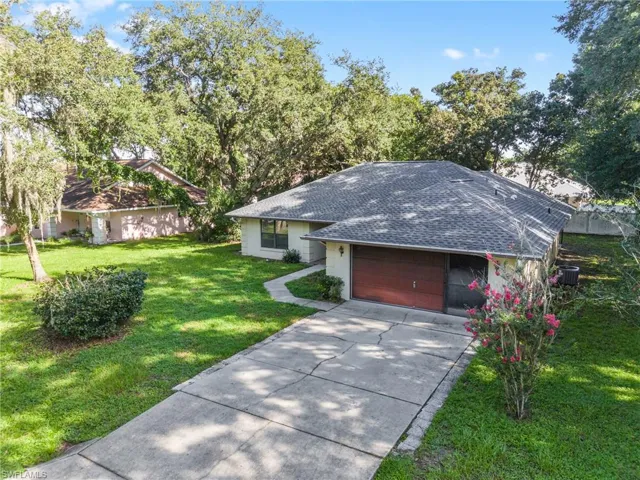 Ranch-style home featuring a garage and a front lawn