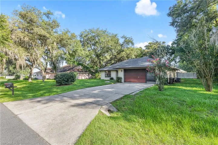Ranch-style home with a garage and a front lawn
