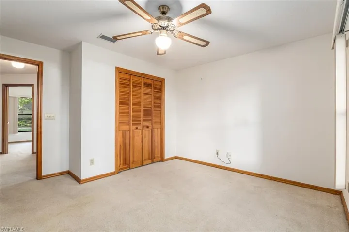 Unfurnished bedroom with light colored carpet, a closet, and ceiling fan