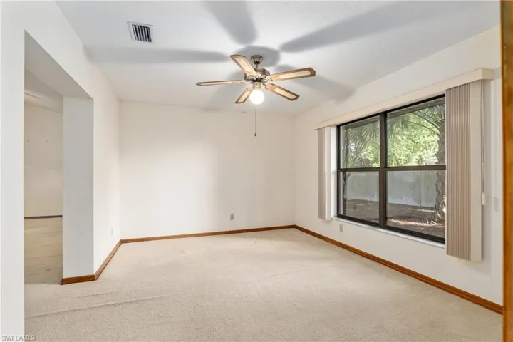 Unfurnished room with ceiling fan and light colored carpet