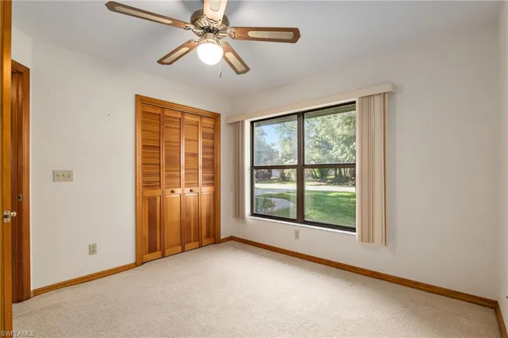 Unfurnished bedroom with a closet, ceiling fan, and light colored carpet