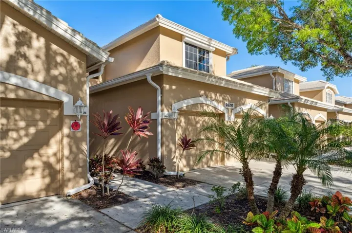 View of front of property featuring stucco siding, a garage, and driveway