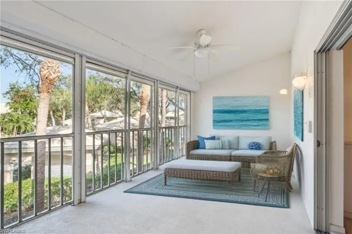 Virtually Staged Sunroom / solarium with a ceiling fan and vaulted ceiling