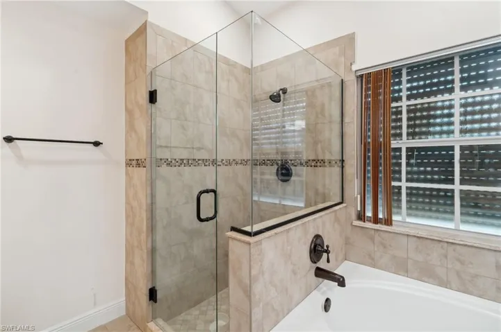 Full bathroom featuring a bath and a shower stall