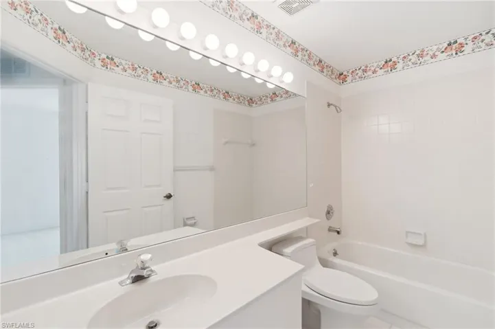 Bathroom featuring vanity, toilet, and tub / shower combination