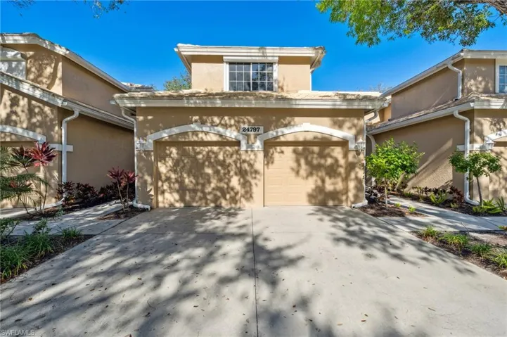 View of front facade featuring stucco siding, a garage, and driveway