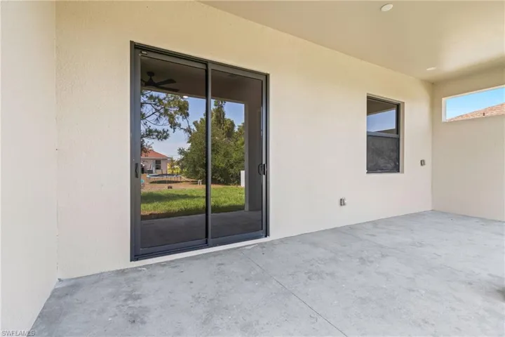 View of exterior entry featuring a patio and stucco siding