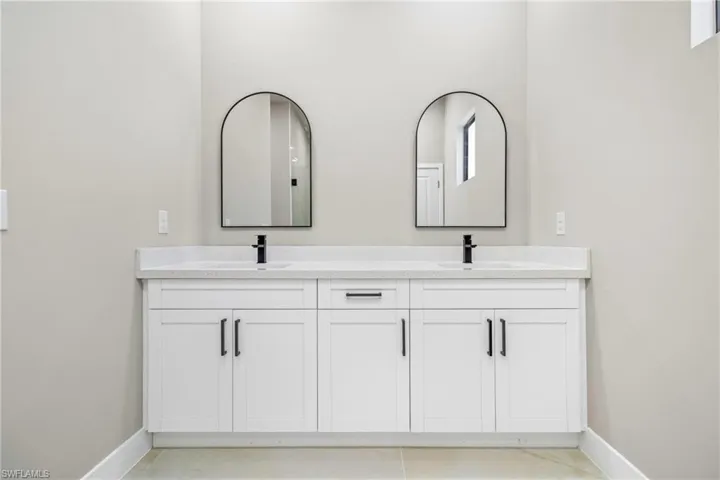 Bathroom featuring double vanity and baseboards