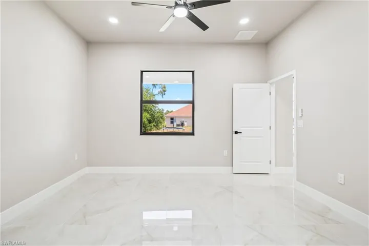 Empty room with ceiling fan, recessed lighting, and light marble finish flooring