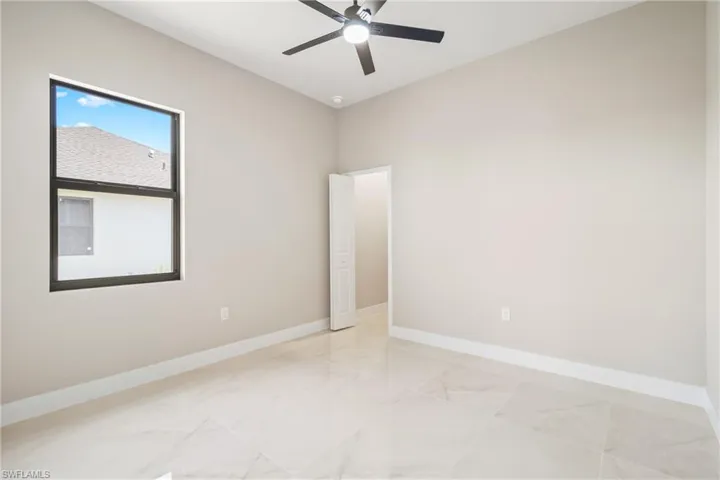 Spare room featuring baseboards and ceiling fan