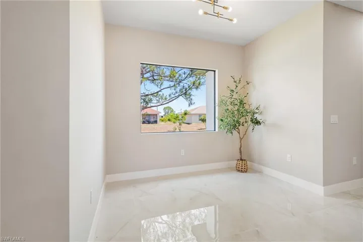 Empty room featuring a chandelier and marble finish floors
