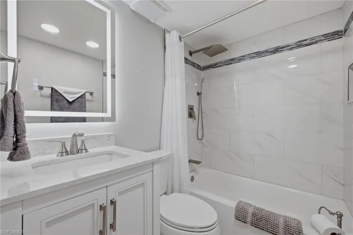 Bathroom featuring a white vanity with brushed nickel hardware and a single basin sink