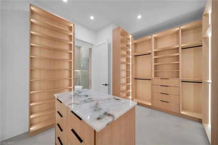 Custom built-in wood-finish cabinetry with integrated lighting and varied shelving