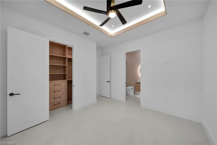 Spacious room featuring light-colored flooring and white walls