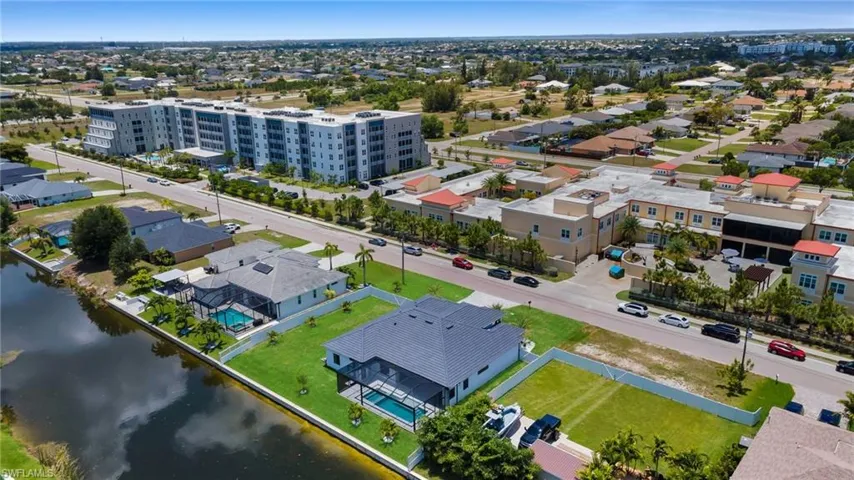 Waterfront property featuring a private boat dock, screened-in swimming pool, and lush green lawn
