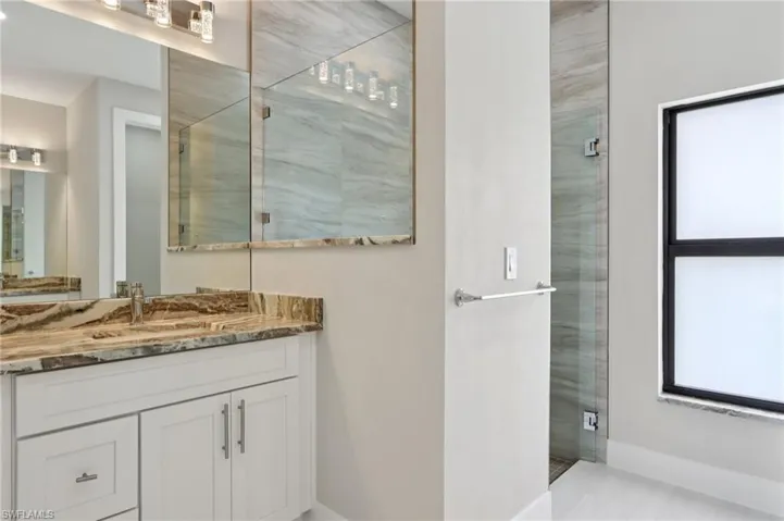 Tiled shower with glass door.