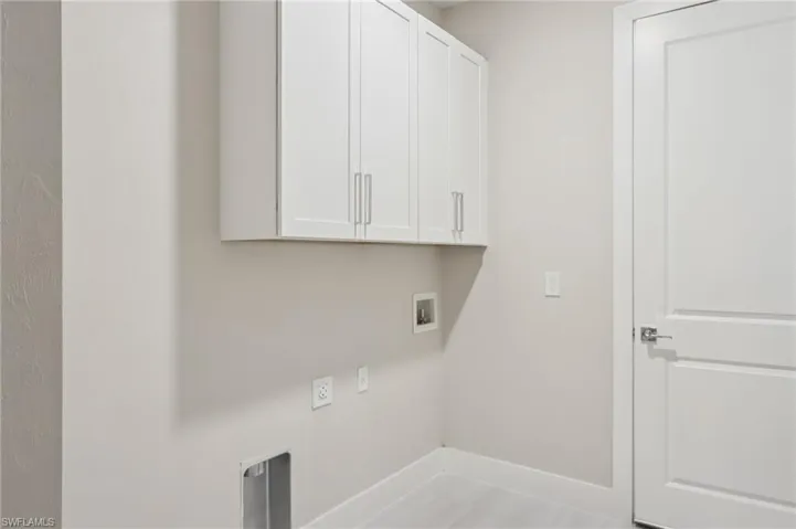 Laundry room with cabinets and washer/dryer hook up.
