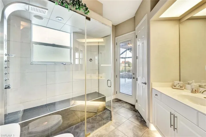 Bathroom with tile patterned flooring, vanity, and an enclosed shower