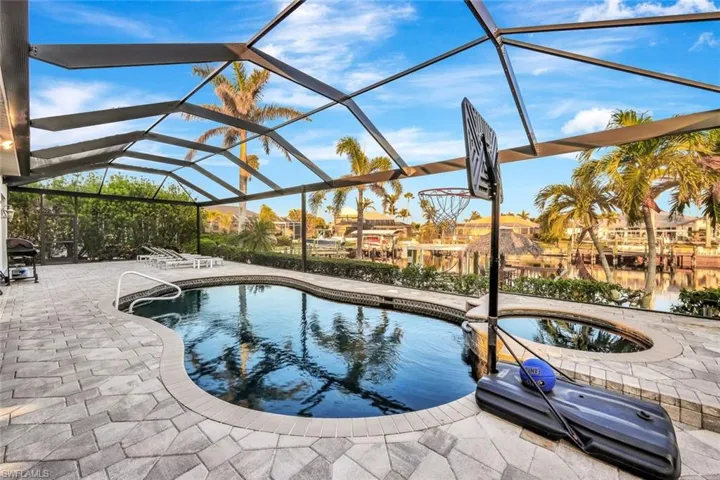 View of pool featuring a lanai, a patio, and a hot tub