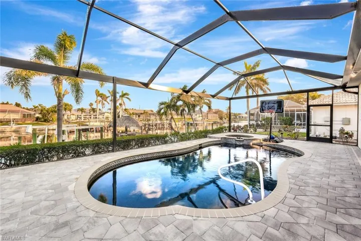 View of pool featuring a patio area, a lanai, and an in ground hot tub
