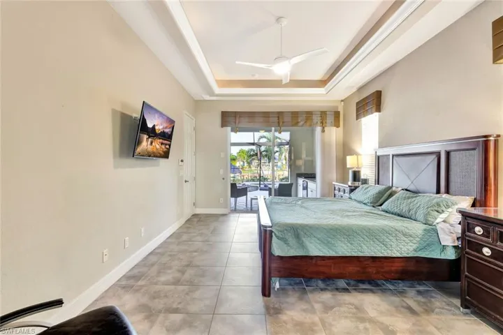 Bedroom with access to outside, a raised ceiling, and ceiling fan
