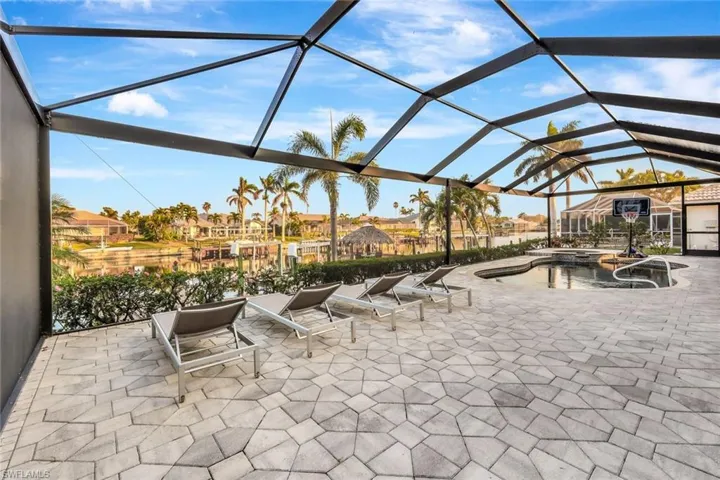 View of patio featuring a swimming pool with hot tub and glass enclosure
