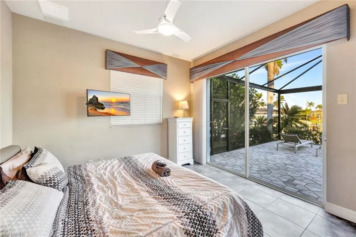 Bedroom featuring access to exterior, ceiling fan, and light tile patterned floors