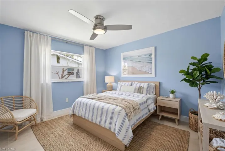 Virtually Staged...Bedroom #3 featuring light blue walls, a ceiling fan with integrated lighting, and a window with white trim
